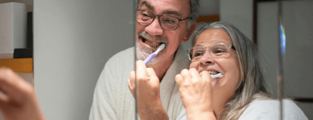 Elderly individuals brushing their teeth as part of their daily routine.